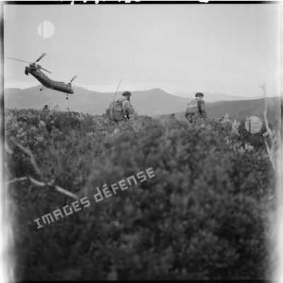 Des bananes (hélicoptères Piasecki H-21) déposent les sections sur les pitons tout proches. Un légionnaire surveille le terrain.