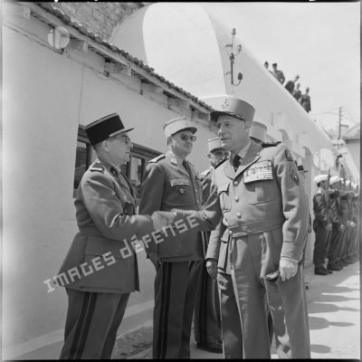 Le général Raoul Salan serre la main d'une autorité lors d'une revue de troupes.