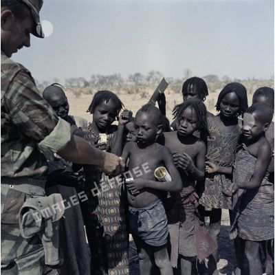 Un soldat français distribue du pain à des enfants tchadiens.