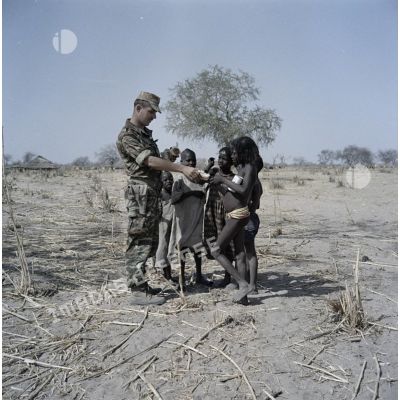 Un soldat français distribue du pain à des enfants tchadiens pendant une halte.