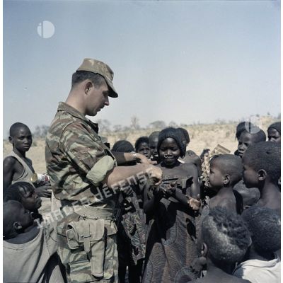 Un soldat français distribue du pain à des enfants tchadiens pendant une halte.