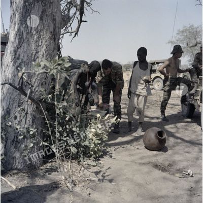 Un soldat français achète des cacahuètes dans un village tchadien pendant une halte.