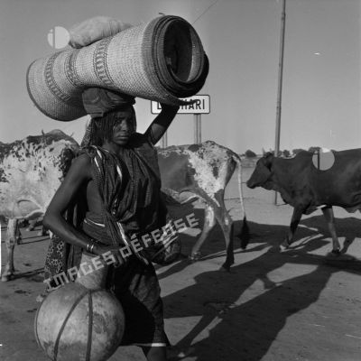 Un Tchadien qui transporte un tapis roulé sur sa tête.