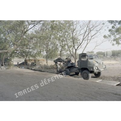 Creusement de tranchées de protection par un engin du génie sur la base Adji Kosseï, PC de l'opération Tacaud à N'Djamena.