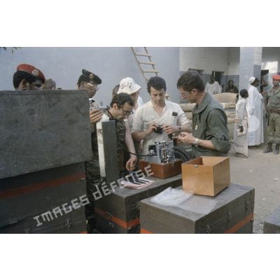 Les membres de l'élément médical militaire d'intervention rapide (EMMIR) déballent les premières caisses de matériel chirugical qui viennent d'arriver au nouveau dispensaire de Kousseri.