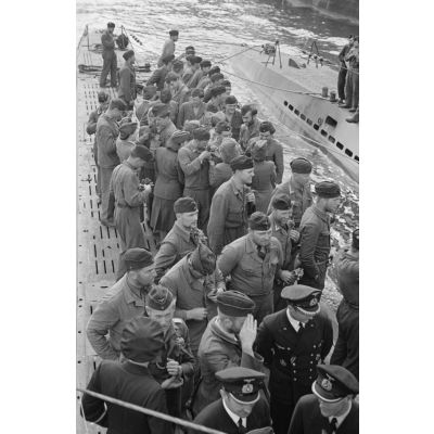 Sur le pont  du sous-marin U-203, des auxilaires de l'amée de terre allemande et des officiers de la Kriegsmarine réservent l'accueil traditionnel aux sous-mariniers.