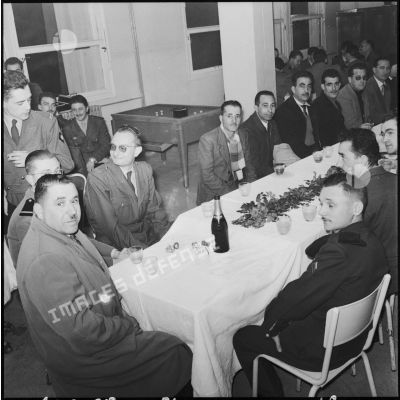 Un groupe d'hommes en compagnie d'officiers lors d'une réception.