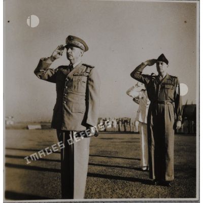 Haut-commissaire de France en Indochine, Georges Thierry d'Argenlieu effectue le salut au drapeau avec des personnalités se tenant derrière lui.
