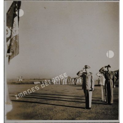Haut-commissaire de France en Indochine, Georges Thierry d'Argenlieu salue le drapeau d'un bataillon de la Légion étrangère en compagnie d'autres personnalités.