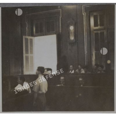 Un homme debout dans la salle du palais de justice où les criminels de guerre japonais passent en jugement.