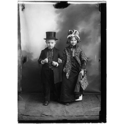 [Deux enfants posent dans un décor de studio déguisés en adultes.]