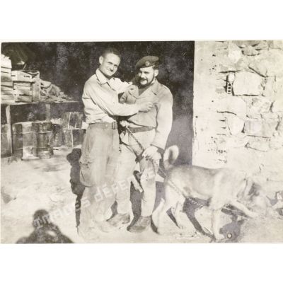 [Portrait de l'appelé du contingent Raymond Le Gall et d'un parachutiste tenant un chien en laisse en Algérie, 1958.]