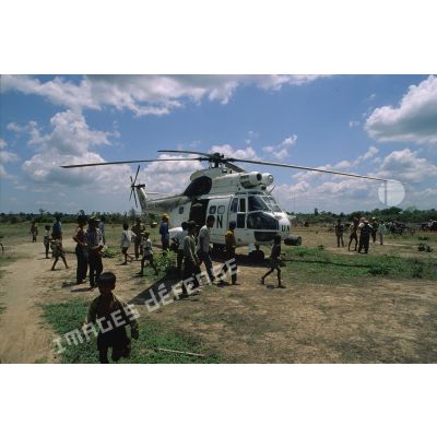 Hélicoptère Puma SA 330 aux couleurs de l'ONU au sol au poste frontière CV2 entre Cambodge et Vietnam, entouré de la population civile.