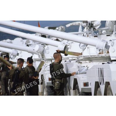 Marsouins du 1er régiment d'infanterie de marine (1er Rima) se relayant pour charger des obus 90 mm dans un véhicule blindé à roues ERC-90 Sagaie aux couleurs de l'ONU.