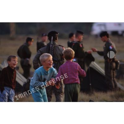 Enfants croates jouant à côté des militaires français au campement installé sur l'autodrome de Rijeka.