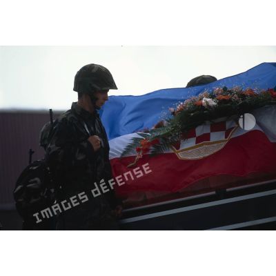 Militaire croate de Bosnie près d'un cercueil couvert de fleurs et du drapeau croate lors d'une levée de corps à Trogir, sur le camp ONU du détachement de l'aviation légère de l'Armée de terre (DETALAT).