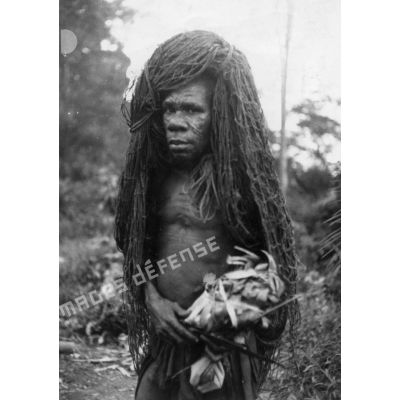 République Gabonaise, 1944. Pygmée portant son filet de chasse sur la tête.