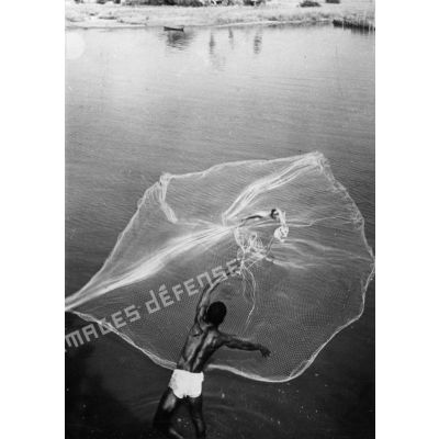 République du Dahomey, lagune de Porto-Novo, 1960. Pêcheur lançant son filet.