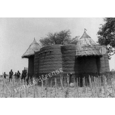 République togolaise, 1953. Case Tamberma dans la région de Nadobe. Au premier plan : chaumes de mil.
