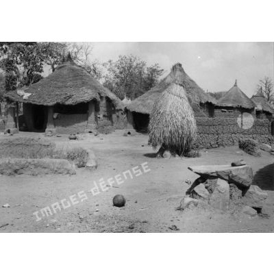 République togolaise, village de Pallakoko, 1954. Au 1er plan, à droite, la pierre qui sert à écraser les graines.