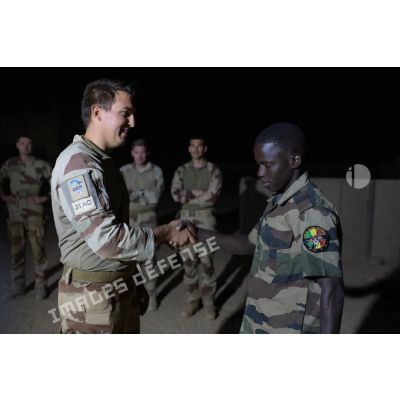 Un guideur aérien tactique avancé (GATA) remet une diplôme à un soldat malien au terme d'une formation au contrôle aérien à Tessalit, au Mali.