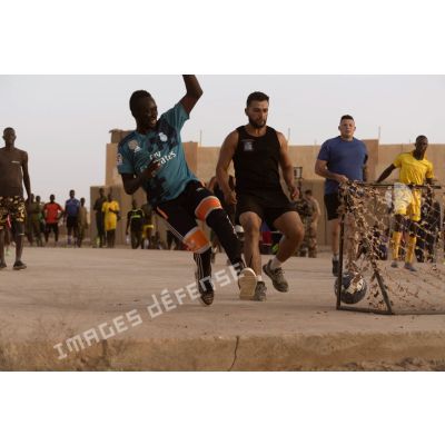 Un soldat malien marque un but lors d'un match de football à Tessalit, au Mali.