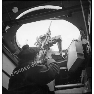 Un marin servant d'une mitrailleuse de 7,5 mm est à son poste de combat dans un hydravion sur la base d'aéronautique navale de Lanvéoc-Poulmic.