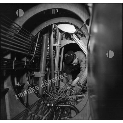 Mécanicien assurant une maintenance dans un hydravion de croisière sur la base d'aéronautique navale de Lanvéoc-Poulmic.
