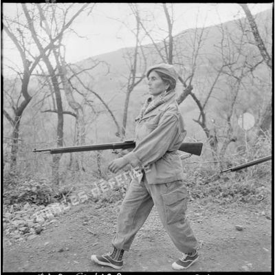Portrait d'une combattante du groupe d'autodéfense de Catinat avançant dans le djebel.