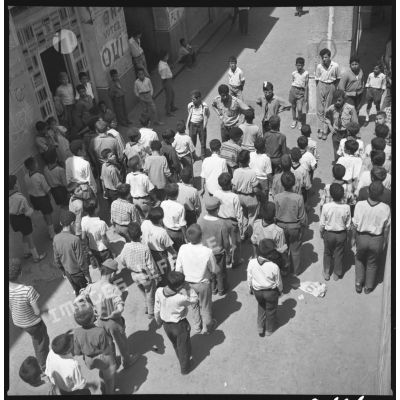 Alger, juin 1962. Au pied de la tour de Diar es Saada, embrigadement des enfants/ado par le FLN (foulards). [légende d'origine]