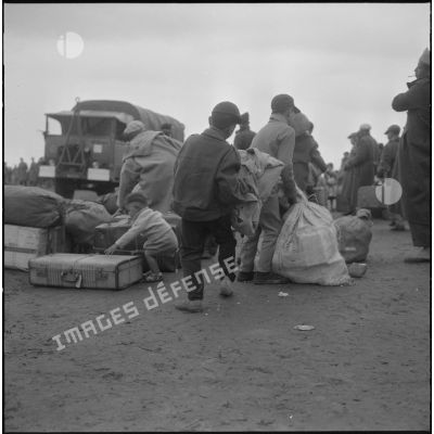 Familles de harkis partant pour la France aidées par les soldats du 26e régiment d'infanterie motorisé (RIM).