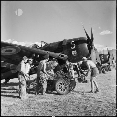 Des armuriers chargent une bombe de 500 livres sur un avion de chasse Bearcat avant son départ en mission sur le terrain de Diên Biên phu.