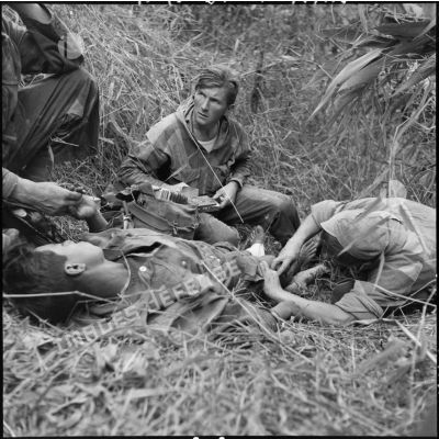 Le médecin-lieutenant Patrice Le Nepvou de Carfort  du 8e bataillon de parachutistes de choc (BPC) apporte les premiers secours à un parachutiste autochtone blessé au cours d'une reconnaissance au nord de Diên Biên Phu.