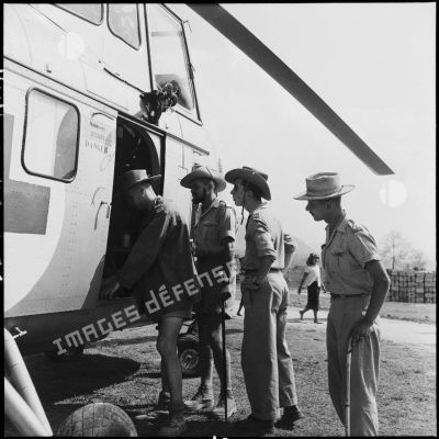 Des officiers autour d'un hélicoptère Sikorsky H-19 sur le camp de Muong Sai.