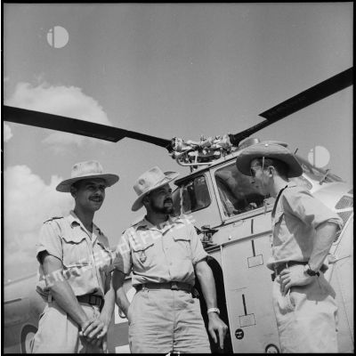 Des officiers devant un hélicoptère Sikorsky H-19 sur le camp de Muong Sai.