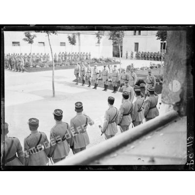 Remise de la médaille militaire au général Pétain par le président de la République. Le général Pétain passe devant les officiers. [légende d'origine]