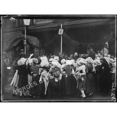 Metz (Lorraine). Voyage de Mr Poincaré. Jeunes filles jetant des fleurs à Mr Poincaré et à Mr Clemenceau. [légende d'origine]