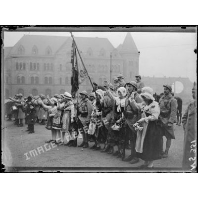 Metz (Lorraine). Voyage de Mr Poincaré. Jeunes Messines encadrant le porte-drapeau d'un régiment et acclamant Mr Poincaré. [légende d'origine]