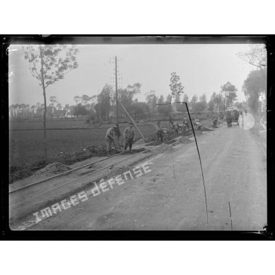 Près de Furnes (Belgique). Soldats belges construisant une ligne ferrée à voie étroite sur la route de Furnes à Ypres. [légende d'origine]
