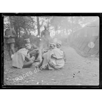Bois d'Houssoy, près de Remaugis (Somme). Camp de tirailleurs sénégalais, 62e bataillon, autour du feu. [légende d'origine]
