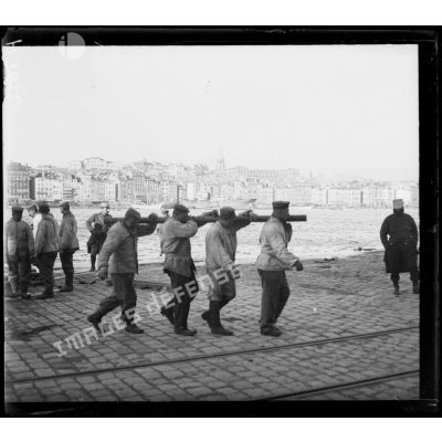 Marseille. Quai du Vieux Port. Prisonniers allemands transportant des barres à obus. [légende d'origine]