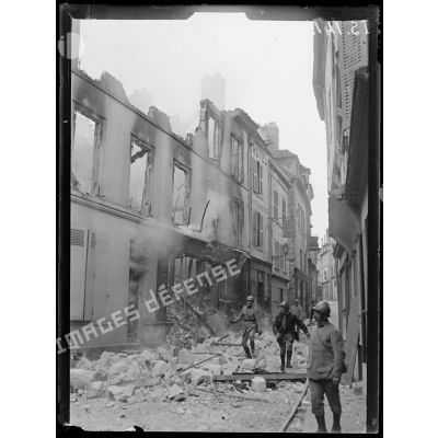 Compiègne, Oise. Place du marché. Angle de la rue des Trois Barbeaux. Maisons incendiées par le bombardement allemand. [légende d'origine]