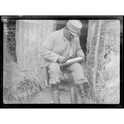 Près Fontaine-lès-Cappy (Somme). Soldat gravant une douille d'obus de 75. [légende d'origine]