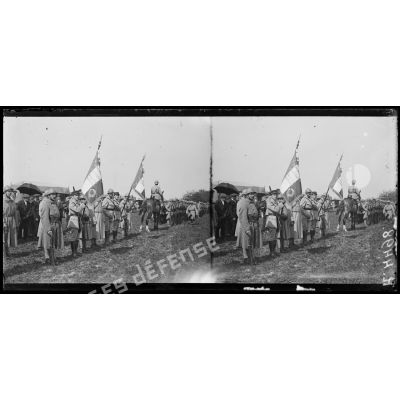 Montagne-Fayel (Somme), à l'escadrille des Cigognes, remise par le commandant Fécamp de la rosette d'officier de la légion d'honneur à l'aviateur Garros, et de la Croix de Chevalier à l'aviateur Marchal. Le drapeau de l'aviation tenu par le sous-lieutenant Fonck et le drapeau de l'aérostation tenu par le lieutenant Botton. [légende d'origine]