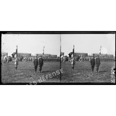 Montagne-Fayel (Somme), à l'escadrille des Cigognes, remise par le commandant Fécamp de la rosette d'officier de la légion d'honneur à l'aviateur Garros, et de la Croix de Chevalier à l'aviateur Marchal. Le drapeau de l'aviation tenu par le sous-lieutenant Fonck et le drapeau de l'aérostation tenu par le lieutenant Botton. [légende d'origine]