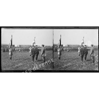 Montagne-Fayel (Somme), le commandant Fécamp décore les aviateurs Garros et Marchal, à gauche le sous-lieutenant Fonck et le drapeau de l'aviation, à gauche le lieutenant Botton et le drapeau de l'aérostation. [légende d'origine]
