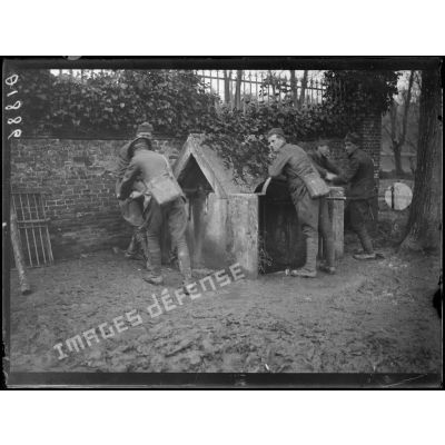 [Des soldats élèvent l'eau d'un puits à l'aide de manivelles.]