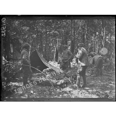 [Scène de la vie quotidienne dans un campement : des soldats italiens montent leurs tentes en pleine forêt, dans la Marne.]