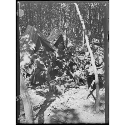 [Scène de la vie quotidienne dans un campement italien, en pleine forêt, dans la Marne : un groupe de soldats joue aux cartes devant une tente.]