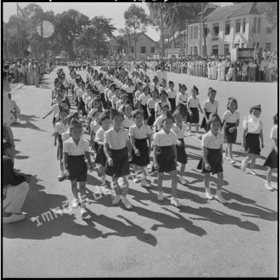 Défilé des écoliers devant la tribune officielle lors d'une cérémonie pour l'anniversaire de la rétrocession Battambang par le Siam.
